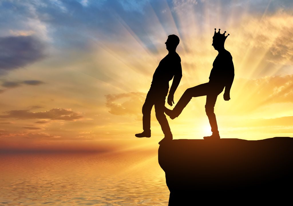selfish man with crown is pushing foot his business partner into abyss concept selfishness betrayal business